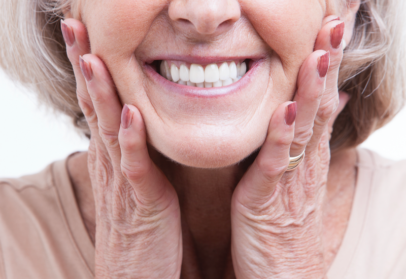 Vyresnio amžiaus moteris turinti baltus ir estetiškus dantis