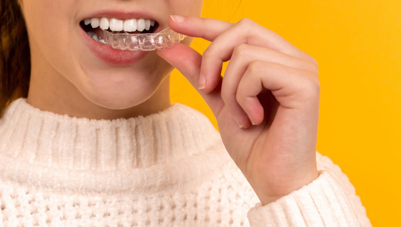 Moteris užsidedanti permatomas tiesinančias dantų kapas