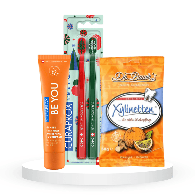 Balinantis komplektas: "Curaprox Be you" balinanti dantų pasta (60 ml), "Curaprox Chistmas 5460" dantų šepetėliai (2 vnt.) ir "Dr. Bauer's Xylinetten" ksilitolio pastilės (30 vnt.)