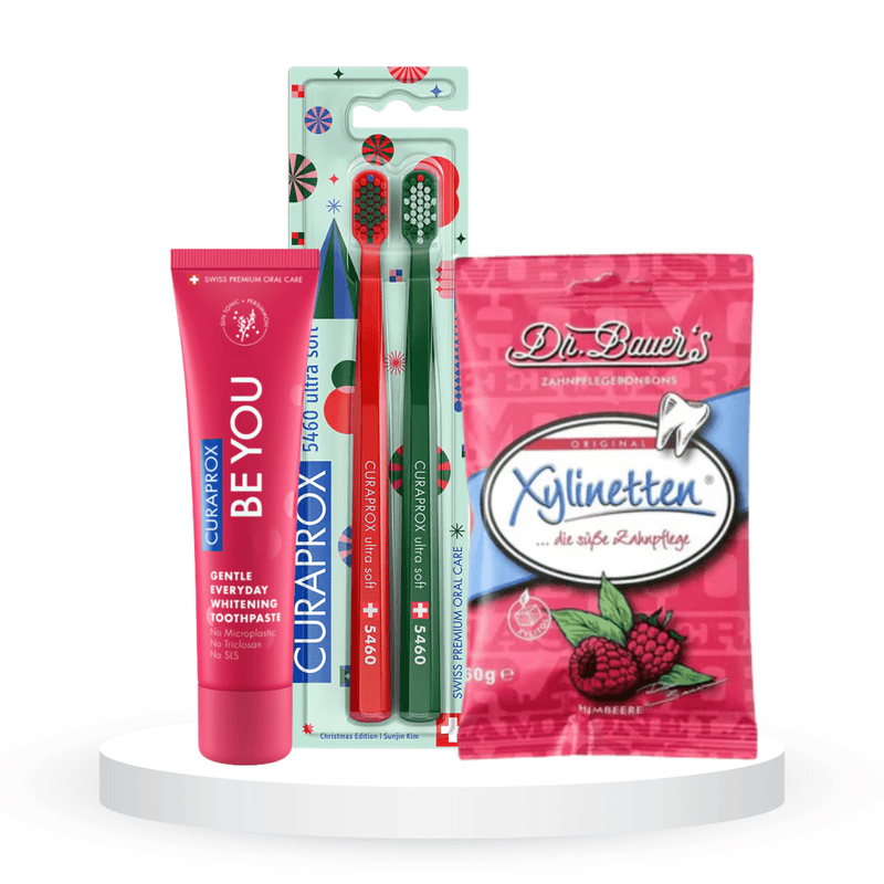 Balinantis komplektas: "Curaprox Be you" balinanti dantų pasta (60 ml), "Curaprox Chistmas 5460" dantų šepetėliai (2 vnt.) ir "Dr. Bauer's Xylinetten" ksilitolio pastilės (30 vnt.)